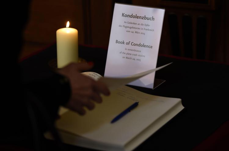 A woman reads pages of a book of condolence for the victims of the Germanwings Airbus A320 plane crash at the Berliner Dom cathedral in Berlin March 25, 2015. There were 144 passengers on board, including two babies, as well as six crew on the Airbus A320 that crashed on March 24, 2015 in the French Alps en route to Duesseldorf from Barcelona. AFP PHOTO / TOBIAS SCHWARZ - AFP