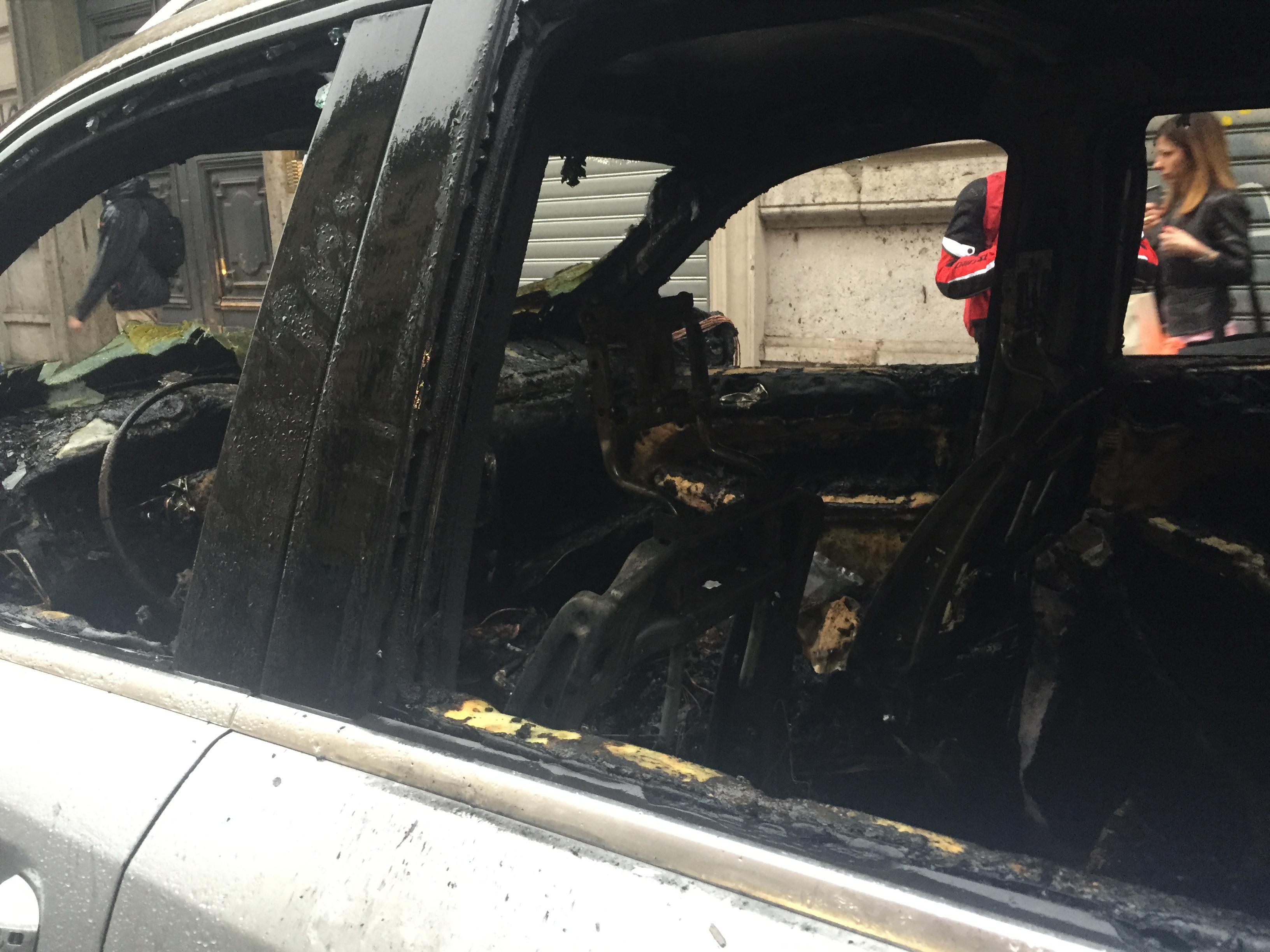 Auto bruciata da incappucciati e black bloc durante il corteo 'No Expo'