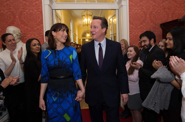 Il premier britannico David Cameron e la moglie Samantha applauditi dallo staff di Downing Street dopo la vittoria elettorale dei Conservatori  (Foto Afp)