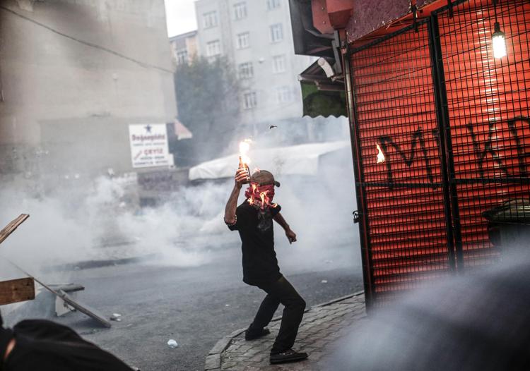 Un manifestante lancia una bottiglia molotov   durante scontri con la polizia turca a Istanbul per protestare contro gli arresti di militanti curdi. (Foto Afp)