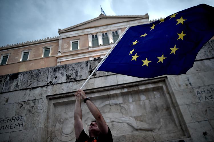 TOPSHOTS A pro-European Union protester waves an EU flag during a demonstration in front of the parliament in Athens on June 30, 2015. 2015. Thousands of people rallied in Athens in support of a bailout deal with international creditors which has been rejected by Prime Minister Alexis Tsipras, leaving Greece on the brink of default. AFP PHOTO / ARIS MESSINIS - AFP