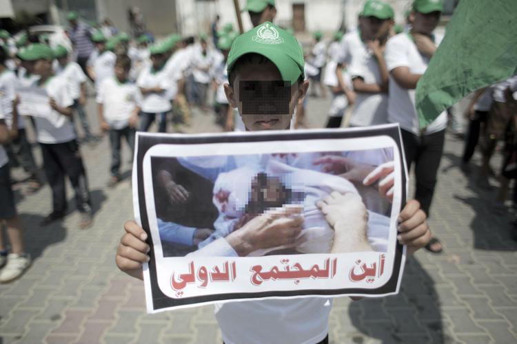 Manifestanti palestinesi in corteo dopo l'uccisone del piccolo Alì (Afp)