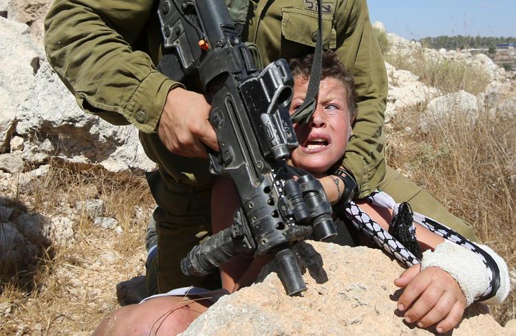 Le violenze  di un soldato israeliano nei confronti di un ragazzino palestinese a Nabi Saleh (foto Afp) - AFP