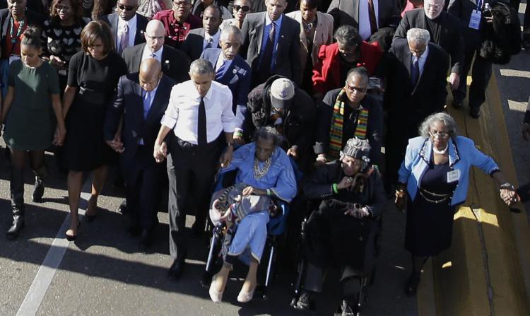 Obama attraversa  il Pettus bridge di Selma accanto ad Amelia Boynton in sedia a rotelle.