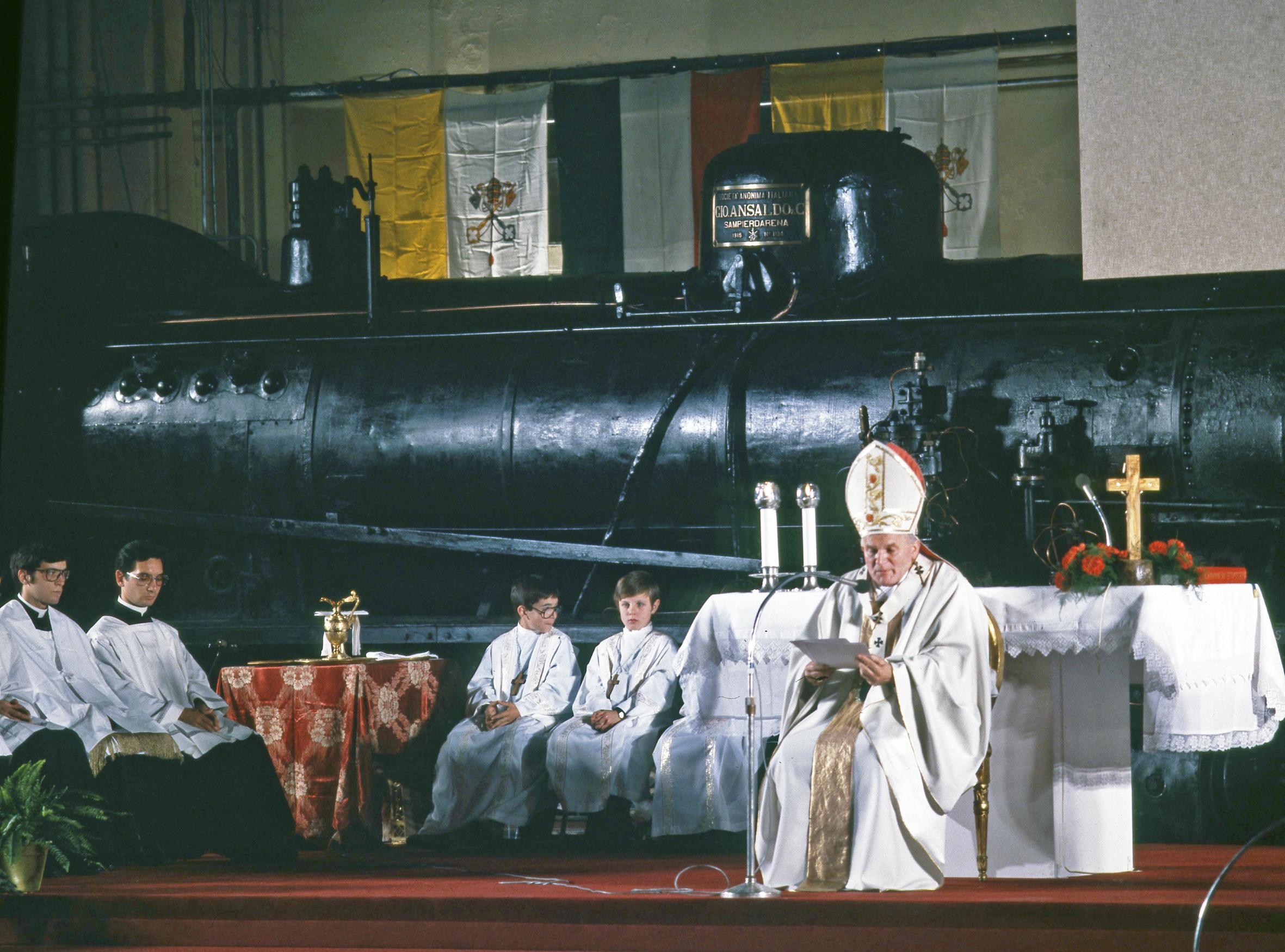 Papa Giovanni Paolo II celebra la Santa Messa su un altare collocato tra una locomotiva a vapore Gr. 740 ed una locomotiva elettrica E. 444 (1979) (Foto Fs italiane)