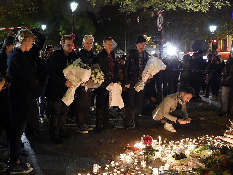 Gli U2 rendono omaggio alle vittime degli attentati davanti al Bataclan (foto Afp) - AFP
