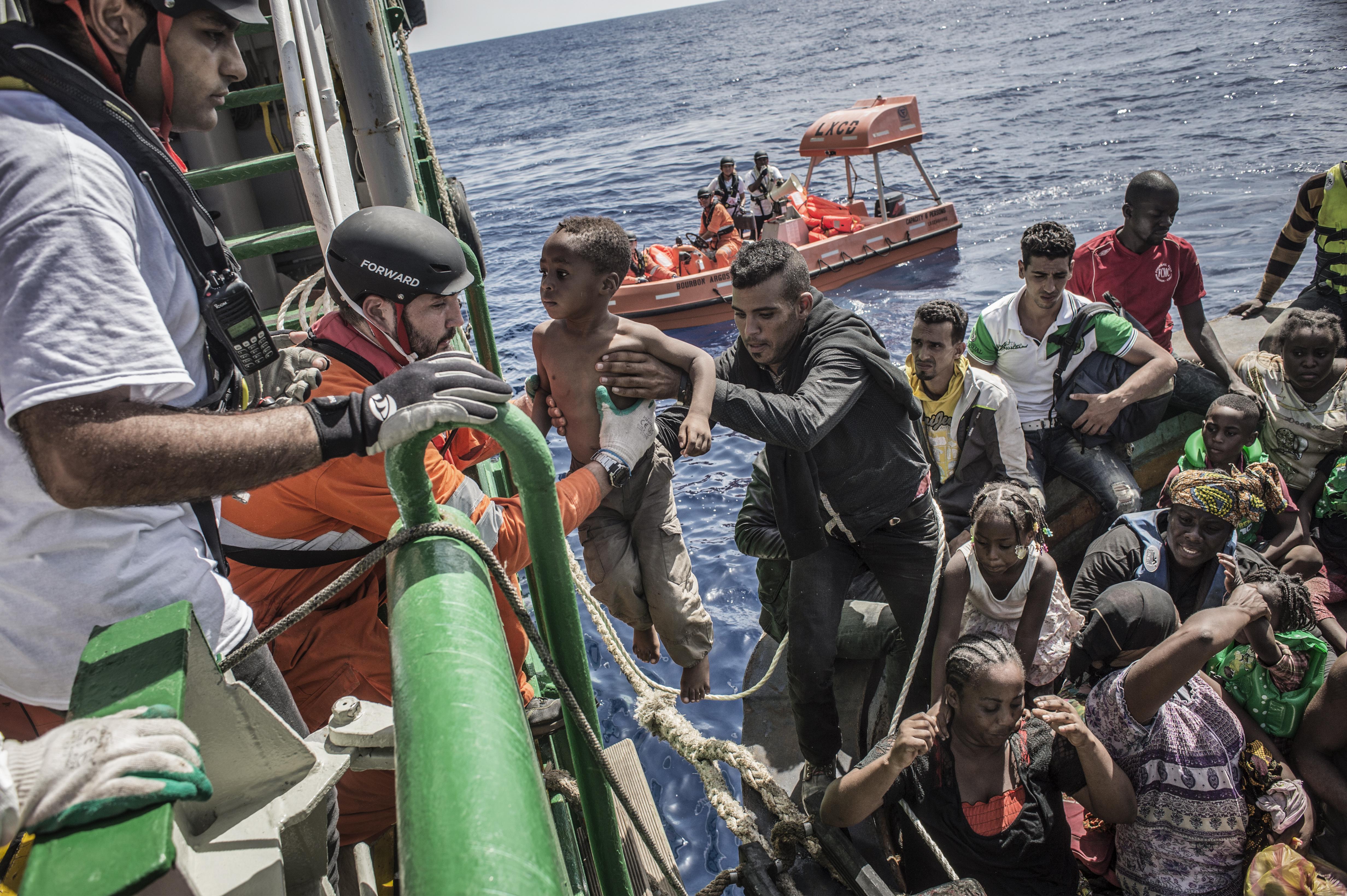 26 agosto 2015. Un bambino viene sollevato da una barca contenente circa 650 persone durante un soccorso nel Mar Mediterraneo da parte del Borbone Argos. (Foto di Francesco Zizola/NOOR)