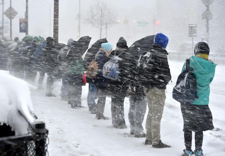 Persone in attesa del bus sotto la neve a New York (Foto Xinhua)