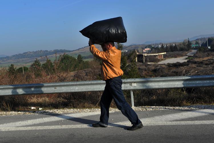 Un migrante con i suoi averi arriva a Idomeni (foto Afp)