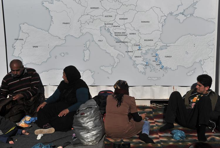 Migranti riposano vicino alla mappa  dell'Europa nei pressi di Idomeni (AFP) - (AFP)