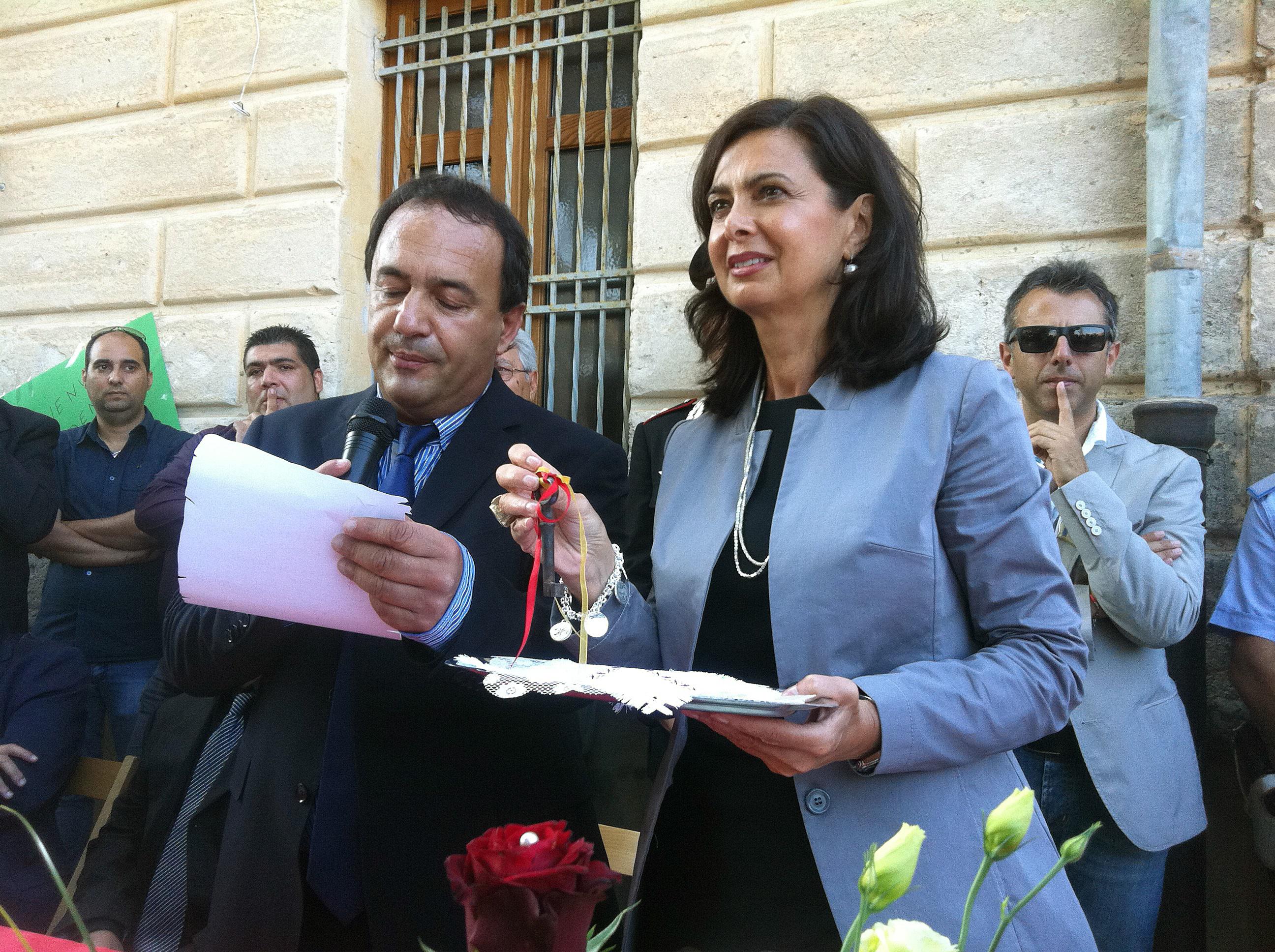 La presidente della Camera, Laura Boldrini, riceve dalle mani del sindaco Domenico Lucano la cittadinanza onoraria di Riace (Fotogramma)