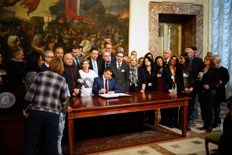 Matteo Renzi mentre firma a Palazzo Chigi la legge sull’omicidio stradale alla presenza di associazioni e familiari delle vittime di incidenti stradali. (Foto Adnkronos)