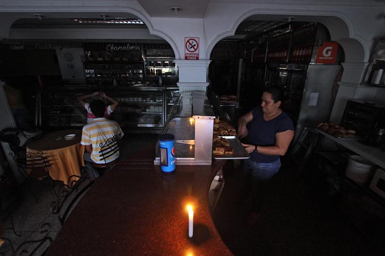 Una bakery di San Cristobal, 600 km da Caracas, dove per risparmiare energia si utilizzano le candele (Foto Afp) - AFP