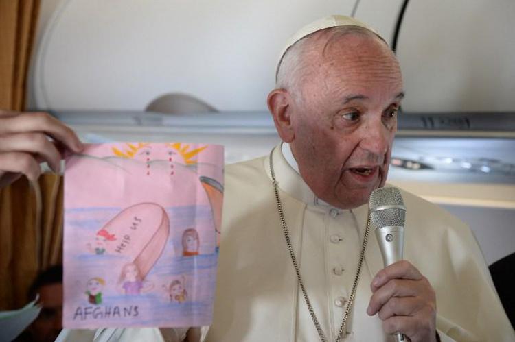 Pope Francis shows drawings made by children on his flight back to Rome following his 16 April visit to the Moria refugee camp on  Lesbos  - Photo: AFP