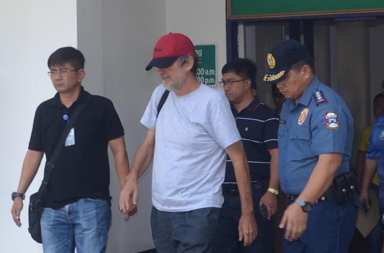 Rolando Del Torchio lascia l'ospedale militare  di Zamboanga, nelle Filippine, scortato dalla polizia dopo la liberazione (Afp)