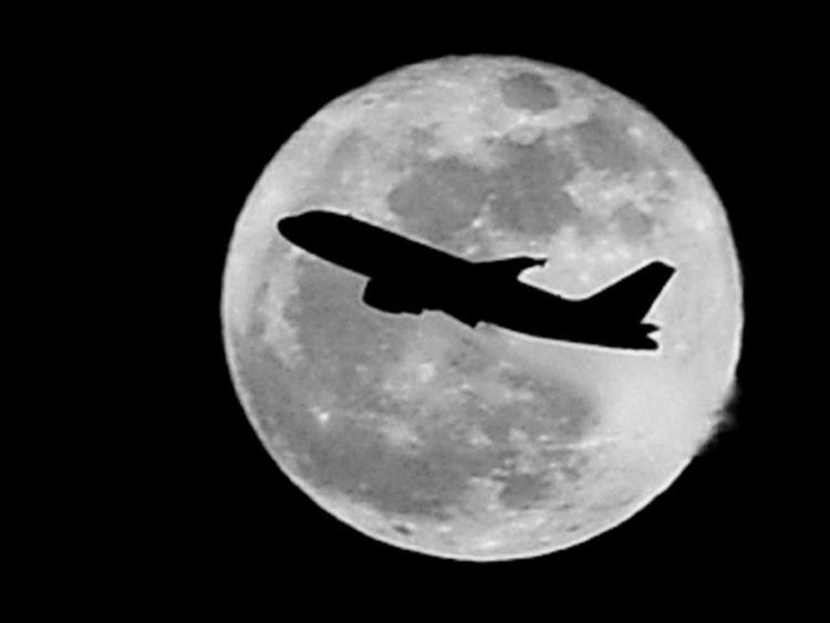 Un aereo attraversa la luna piena (Foto Fotogramma)