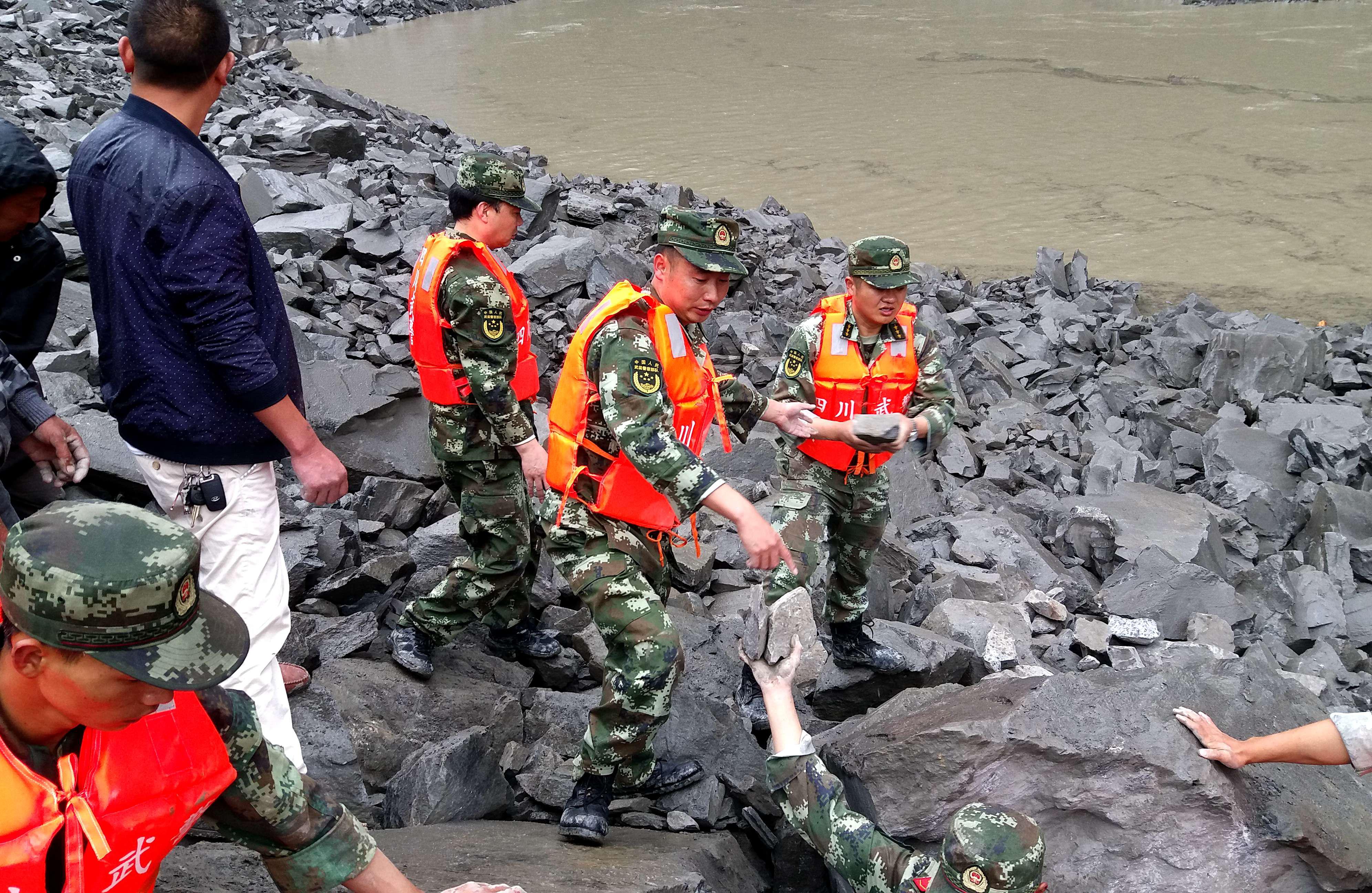 La polizia militare cinese e gli assistenti di soccorso, nel sito di una frana in Xinmo, città di Diexi, AfpAfp