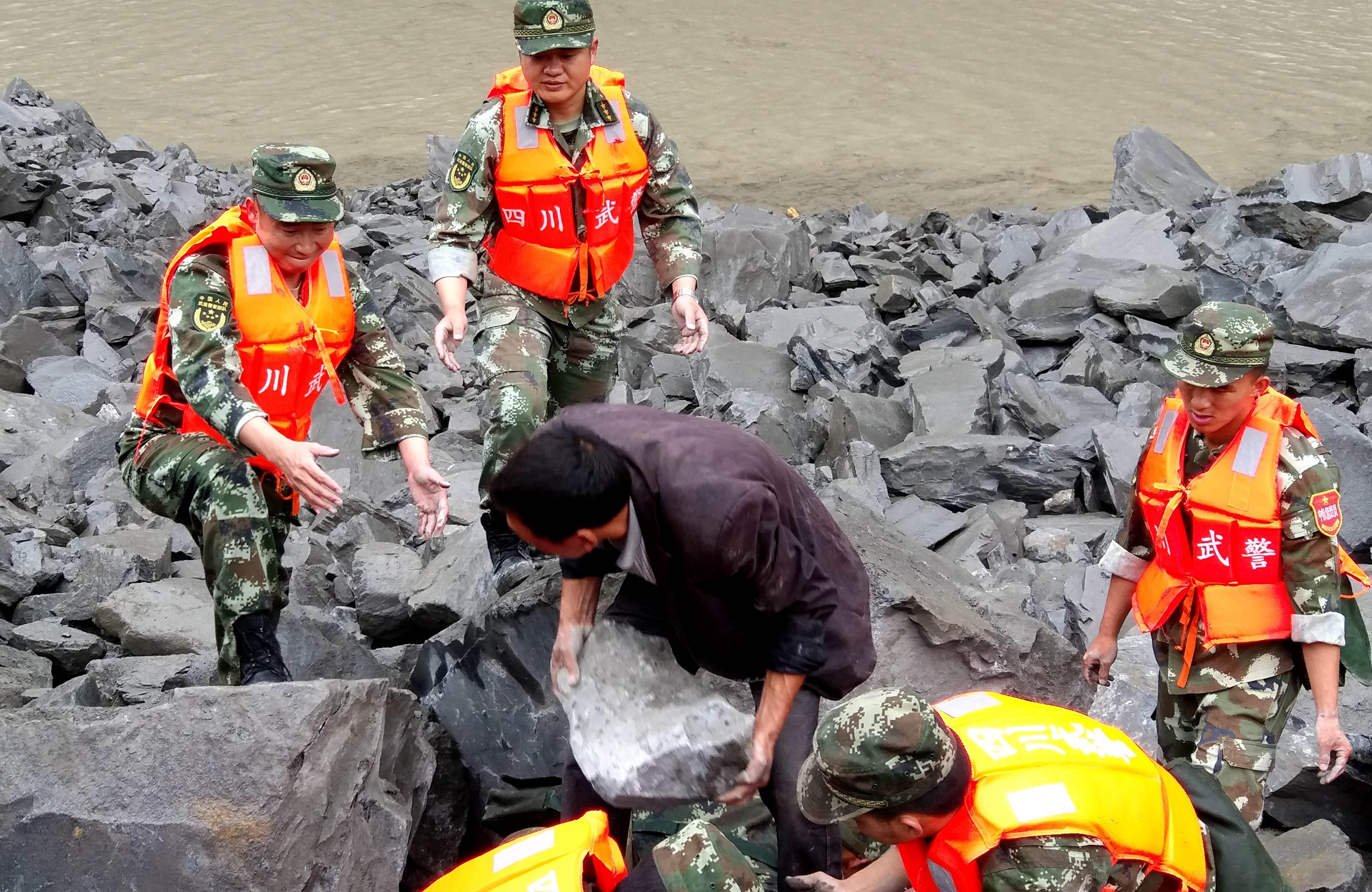 La polizia militare cinese e gli assistenti di soccorso, nel sito di una frana in Xinmo, città di Diexi, Afp