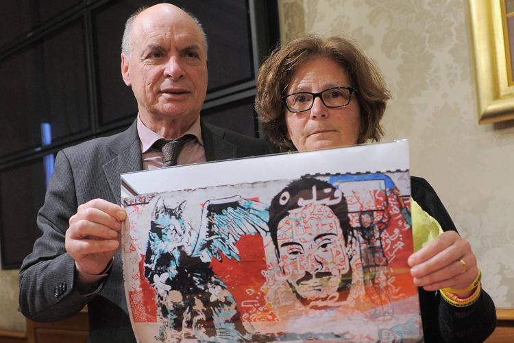 Giulio Regeni's parents Paola Deffendi (R) and Claudio Regeni (L) hold up a poster of their son. - FOTOGRAMMA