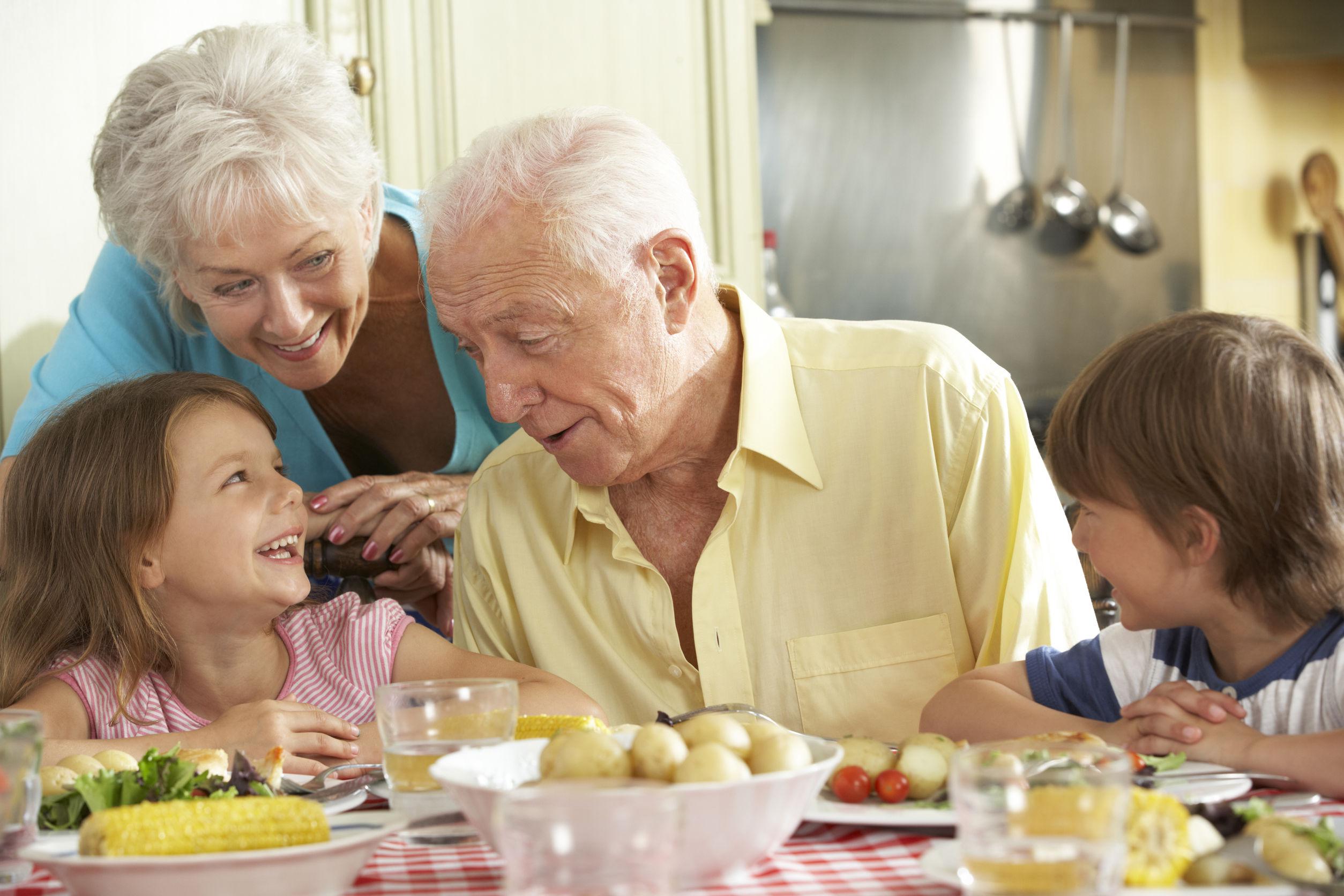 42251126 - grandparents and grandchildren eating meal together in kitchen