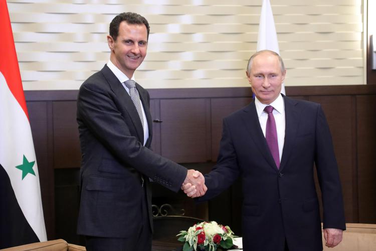 Bashar al-Assad (L) shakes hands with Russia's President Vladimir Putin (R)  - Photo: AFP