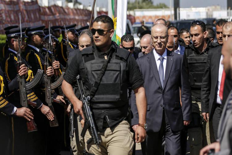 Il premier del governo dell'Anp, Rami Hamdallah (al centro), scortato  dalla sicurezza al suo arrivo a Gaza (Afp) - AFP