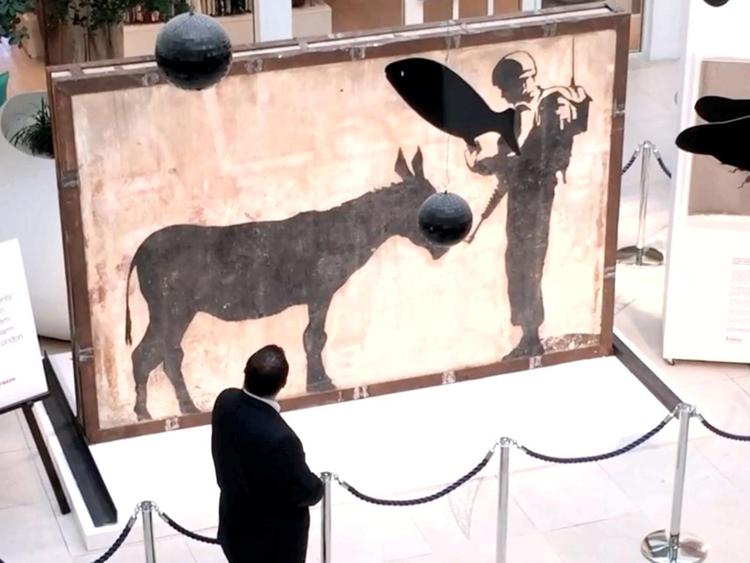 Una scena di 'The man who stole Banksy' con una delle immagini più iconiche dell'artista   