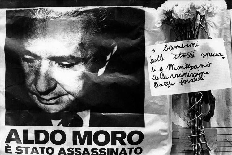 MANIFESTO APPESO AL MURO ANNUNCIA L'ASSASINIO DI ALDO MORO DOPO IL SUO RAPIMENTO DA PARTE DELLE BR, BRIGATE ROSSE, FIORI ACCANTO ALLA SUA FOTO ag. GIACOMINOFOTO/FOTOGRAMMA ph. BRUNI; luogo: ROMA; data: 1975 (BRUNI, ROMA - 1978-05-09) p.s. la foto e' utilizzabile nel rispetto del contesto in cui e' stata scattata, e senza intento diffamatorio del decoro delle persone rappresentate - FOTOGRAMMA