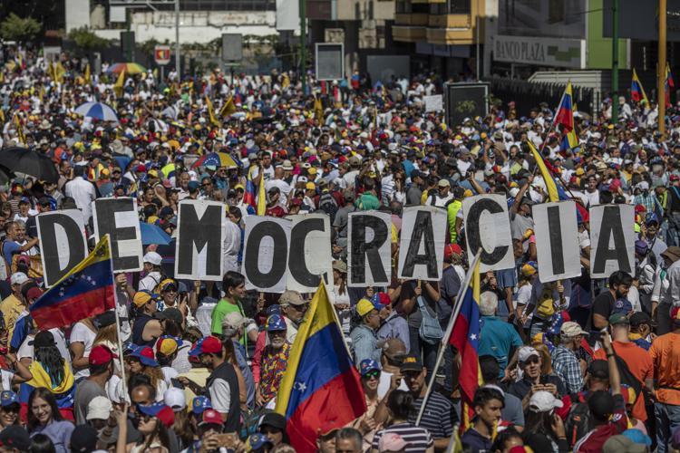 Demonstrators hold signs spelling during a pro-opposition protest in Caracas, Venezuela, on Saturday. Bloomberg photo by Alejandro Cegarra - Bloomberg