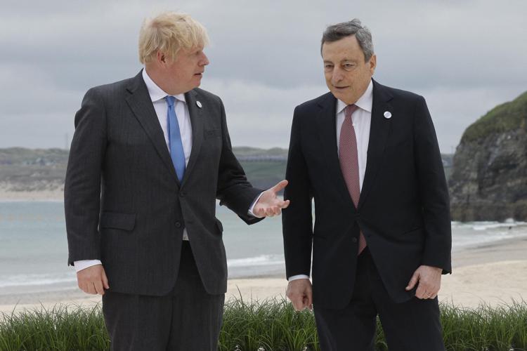 Britain's Prime Minister Boris Johnson (L) welcomes Italy's Prime minister Mario Draghi prior to the start of the G7 summit in Carbis Bay, Cornwall on June 11, 2021. - G7 leaders from Canada, France, Germany, Italy, Japan, the UK and the United States meet this weekend for the first time in nearly two years, for three-day talks in Carbis Bay, Cornwall. (Photo by Ludovic MARIN / AFP)
