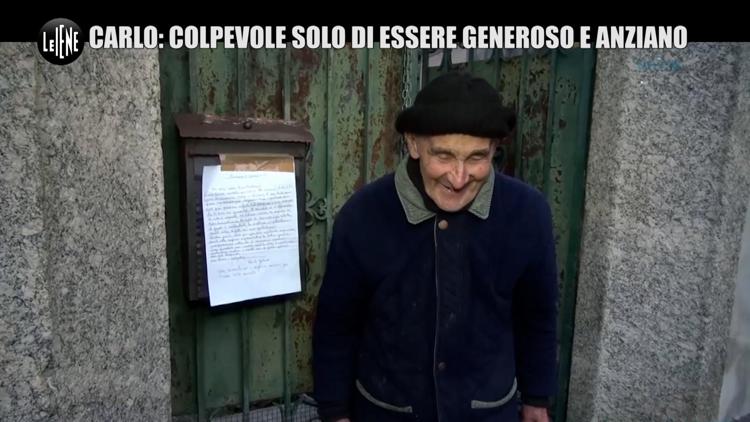 Carlo Gilardi posa davanti a ìlla sua casa con una lettera di suo pugno nella quale denuncia il pericolo di perdere la propria libertà - (ufficio stampa Le Iene)