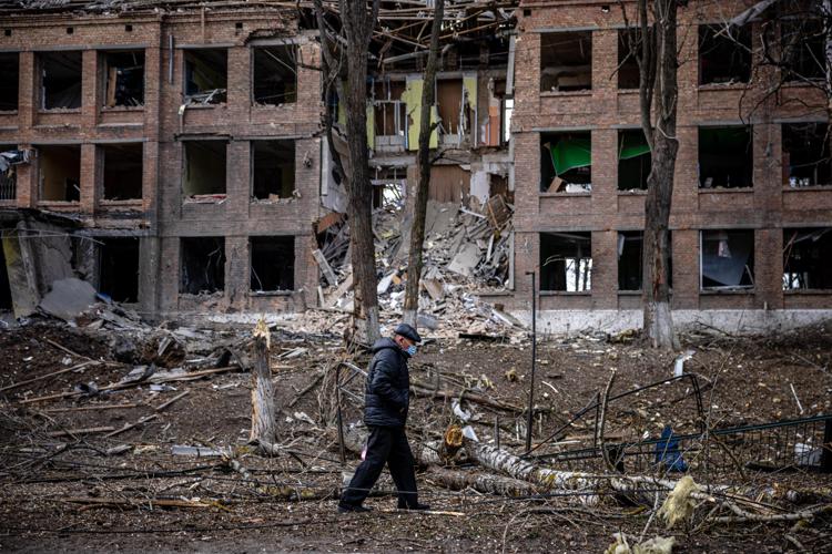 A man walks in front of a destroyed building after a Russian missile attack in the town of Vasylkiv, near Kyiv, on February 27, 2022. - Ukraine's foreign minister said on February 27, that Kyiv would not buckle at talks with Russia over its invasion, accusing President Vladimir Putin of seeking to increase 