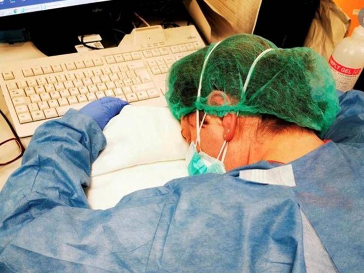 La foto simbolo della pandemia di Covid con l'infermiera distrutta dopo turni massacranti - Ipa