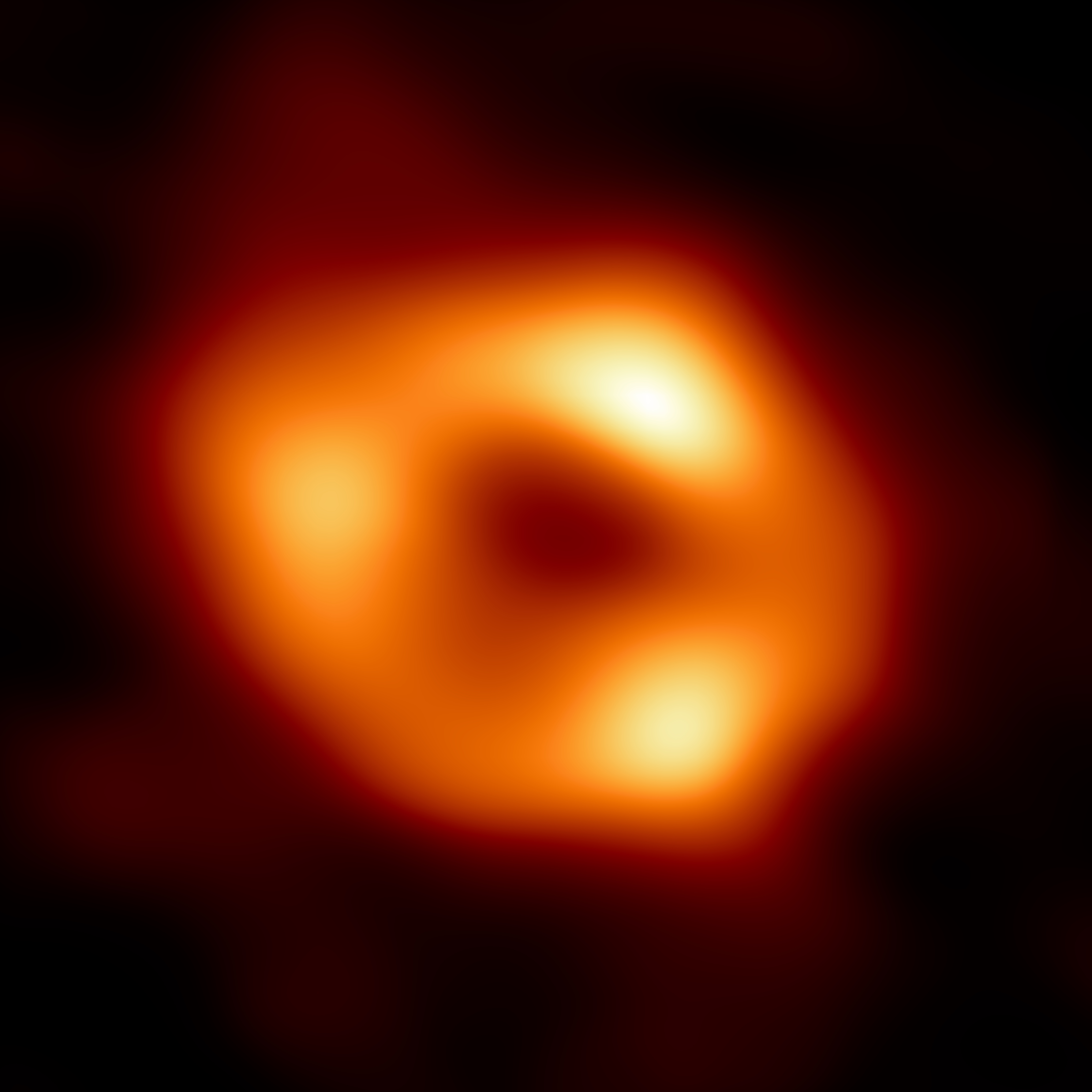 Questa è la prima immagine di Sagittarius A* (Sgr A*), il buco nero supermassiccio al centro della nostra galassia, la Via Lattea. È la prima prova visiva diretta della presenza di questo buco nero. L’immagine è stata realizzata dall'Event Horizon Telescope (EHT), un array che collega otto osservatori radioastronomici in tutto il mondo a formare un unico telescopio virtuale delle dimensioni della Terra. Il progetto prende il nome dall'orizzonte degli eventi, il confine di un buco nero oltre il quale nulla può sfuggire, nemmeno la luce. Anche se non possiamo vedere il buco nero stesso, perché non emette luce, il gas che brilla attorno ad esso possiede un aspetto distintivo: una regione centrale scura (chiamata “ombra” del buco nero) circondata da una struttura brillante a forma di anello. La nuova immagine cattura la luce distorta dalla potente gravità del buco nero, che ha una massa pari a quattro milioni di volte quella del Sole. L'immagine del buco nero Sgr A* è una media delle diverse immagini che la Collaborazione EHT ha estratto dalle sue osservazioni del 2017.  - EHT Collaboration