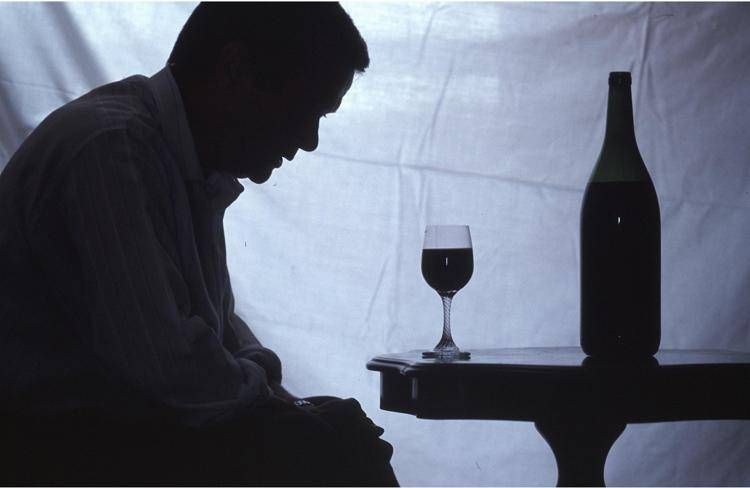 Un uomo davanti a una bottiglia di vino - FOTOGRAMMA