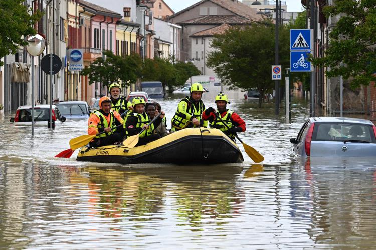 Alluvioni 2023, Vigili del fuoco a bordo di un canotto per le strade allagate - (Afp)