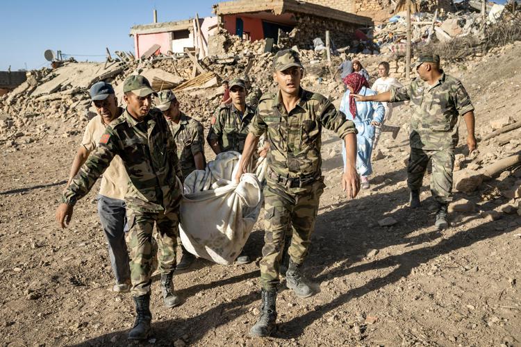 Militari marocchini trasportano il corpo di una vittima del terremoto che ha ucciso almeno 2.000 persone nel Paese - Afp