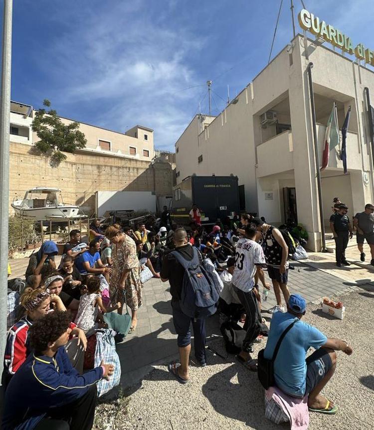 Migranti davanti la sede della Gdf