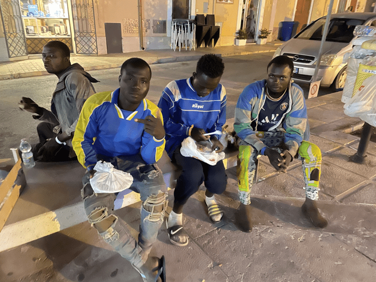 I migranti davanti alla chiesa di Lampedusa