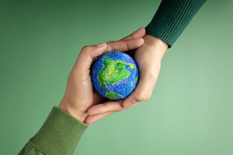 Due mani sostengono pianeta green - Canva