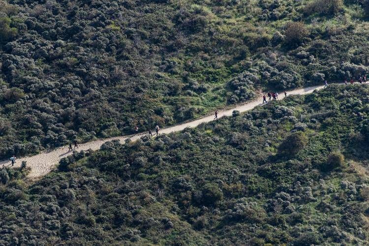 Migranti che camminano lungo un sentiero sabbioso a Gravelines - (Afp)
