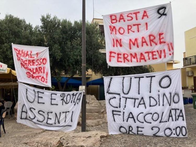 Cartelloni di protesta in piazza a Lampedusa