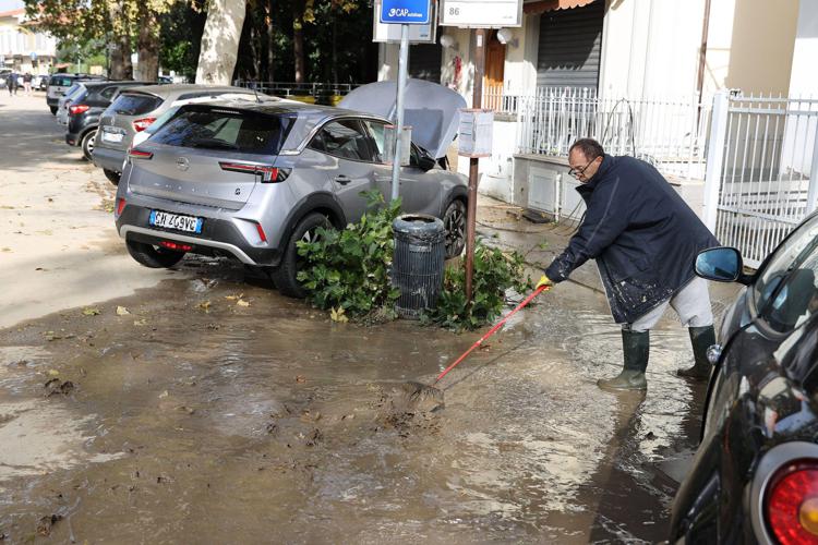 Uomo spala il fango in Toscana dopo l'alluvione - (Fotogramma)