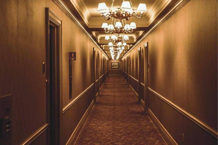Luci accese nel corridoio di un hotel - Canva