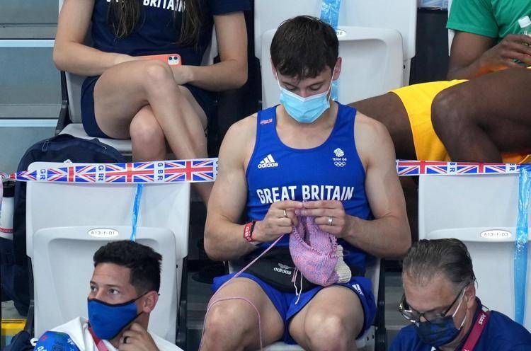 Tom Daley ai Giochi Olimpici di Tokyo, seduto sugli spalti e intento a lavorare all'uncinetto  - Fotogramma /Ipa