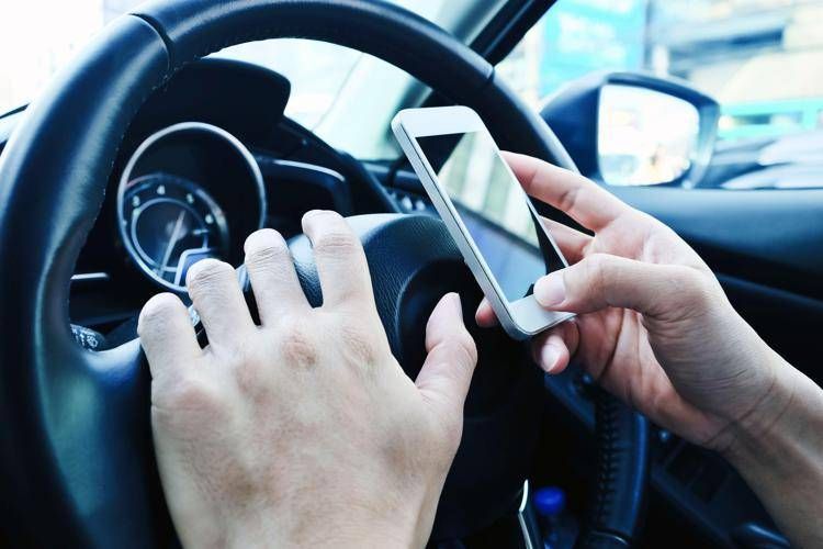 Un uomo usa il cellulare mentre guida - (Foto )