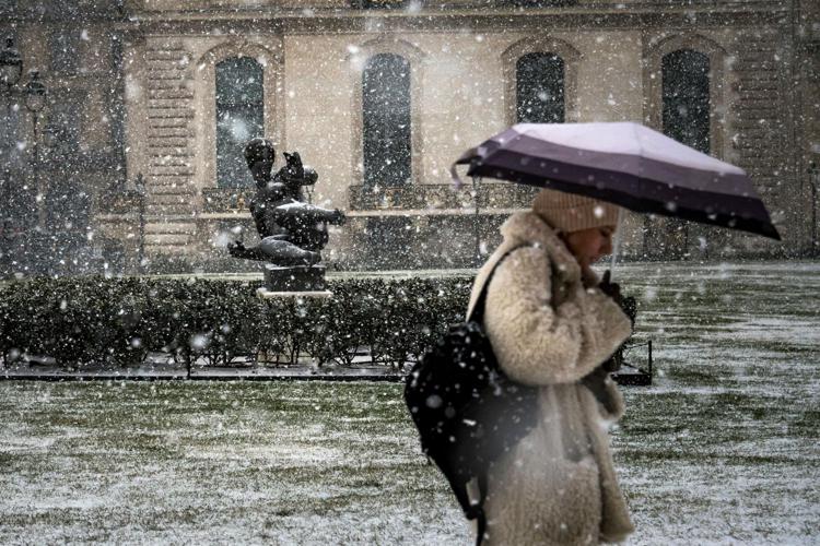 Donna con ombrello sotto la neve - Afp