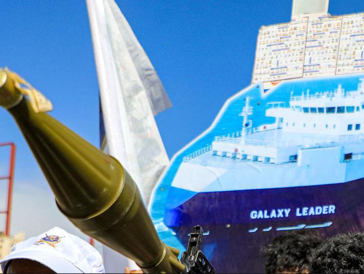 Miliziani Houthi con un cartello raffigurante la nave 'Galaxy Leader' (Afp)