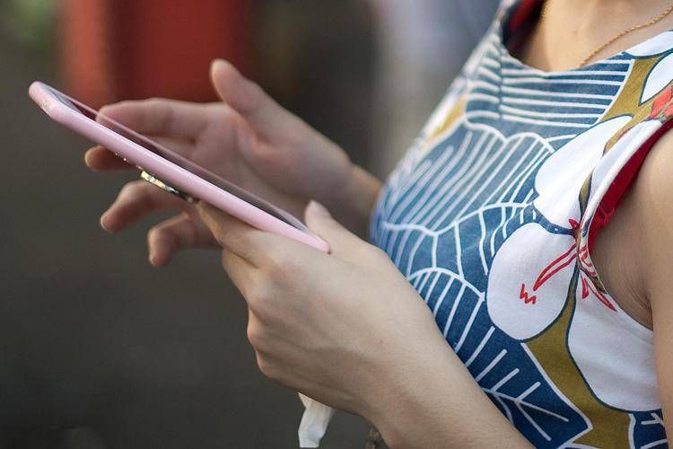 Ragazza con uno smartphone in mano - (Afp)