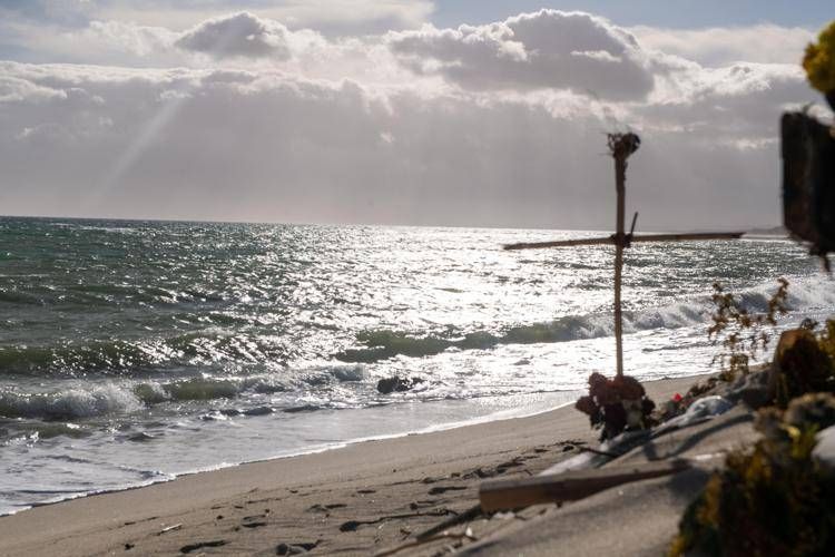 Una croce sulla spiaggia di Cutro (Fotogramma)